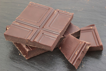 Natural bitter chocolate pieces on slate plate background closeup