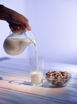 Pours Milk on wooden background close-up shot