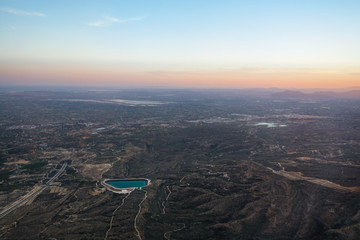 Aerial shot of miniature civilizations creating infrastructure for more villages and cities. Human made artificial lake for irrigation.  