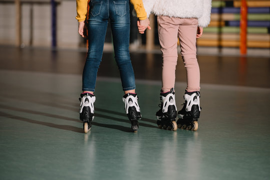 Partial view of children in roller skates holding hands