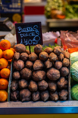 Sweet potato pile with a price tag at a market