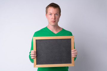 Portrait of young handsome man holding blackboard