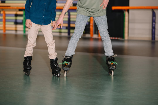 Cropped view of trainer and boy in roller skates