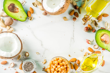 Healthy vegan fat food sources, omega3, omega6 ingredients - almond, pecan, hazelnuts, walnuts, olive oil, chia seeds, avocado, coconut,  banner copy space