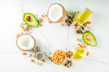 Healthy vegan fat food sources, omega3, omega6 ingredients - almond, pecan, hazelnuts, walnuts, olive oil, chia seeds, avocado, coconut,  banner copy space
