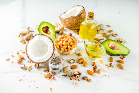 Healthy vegan fat food sources, omega3, omega6 ingredients - almond, pecan, hazelnuts, walnuts, olive oil, chia seeds, avocado, coconut,  banner copy space