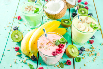 Summer refreshing drinks - protein shakes, milkshakes or smoothies, with fresh berry and fruits, light blue table copy space