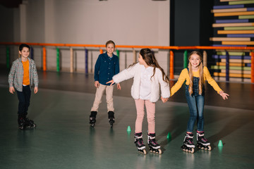 Fototapeta premium Friends in roller skaters laughing and holding hands