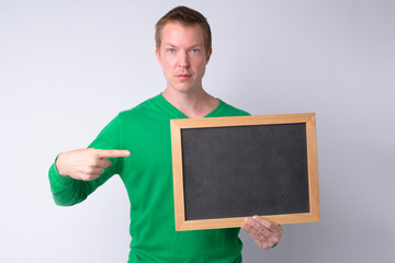 Portrait of young handsome man pointing at blackboard