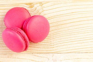 Macaroons pile on a white rustic wooden background with copy space (place for text)