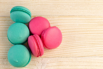 Macaroons pile on a white rustic wooden background with copy space (place for text)