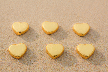 Chocolate color Lovely golden heart on the beach. Background is a natural in real place, creative Valentine's Day Concept, tropical style background made in Phuket, Thailand.