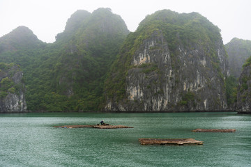 Fototapeta na wymiar Halong Bay in mystical clouds. Mystical atmoshpere in the world famous halong bay.