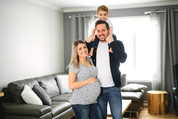Fototapeta na wymiar A Beautiful pregnant mother and father with her children at the living room