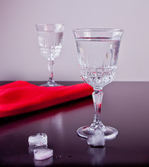 Cold drink with ice in a heart shape on the black background