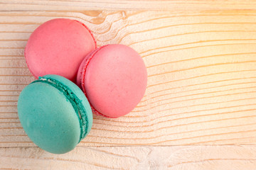 Macaroons pile on a white rustic wooden background with copy space (place for text). Toned