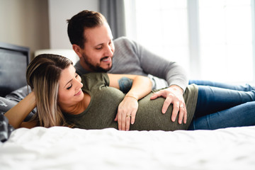 The parents in bed expecting a little baby, Romantic moments for pregnant couple