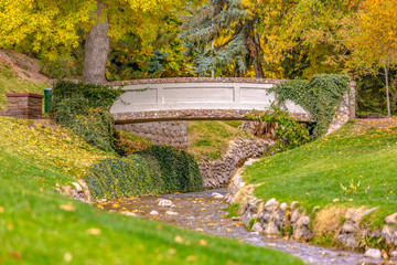 Stone bridge over a stream against lush trees
