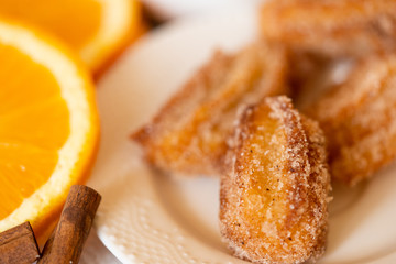 Spanish cuisine: churos and orange close-up on the table