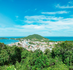 Fototapeta premium Bombinhas - SC, Brazil. Panoramic view of the touristic city of Bombinhas and some beaches with blue sea around the hill. Coastal city on a beautiful sunny day.