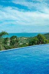 Pool on the edge of a hill with a view to the sea. Infinity pool. Ilha do Arvoredo island on background, Bombinhas SC - Brazil.