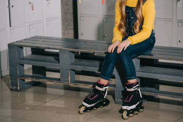 Cropped view of child with long hair posing in roller skates