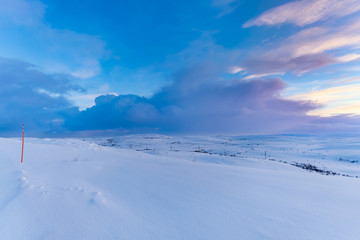 Colors of the North. A beautiful frozen landscape in Russia's Kola peninsula, above the Arctic Circle. The red pole on the far left actually signals where the road ends.