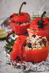 red bell peppers stuffed with meat, rice and cranberries, close-up