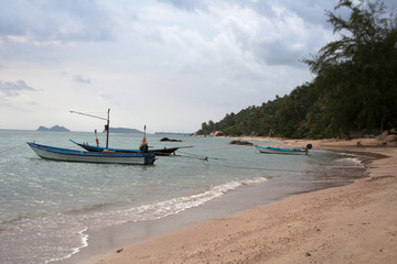 Fototapeta na wymiar Koh Phangan island riviera with long-tail boats and sand beach