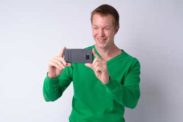 Happy young handsome man taking picture with phone