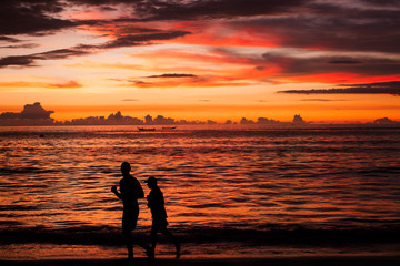 Background sky sunset,Silhouette Jogging on the beach,Bright in Phuket Thailand.
