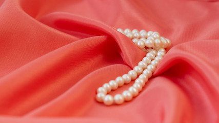 Beautiful background, on fabric color living coral are pearl beads