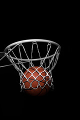 Fototapeta na wymiar Ball falling through a Basketball Hoop