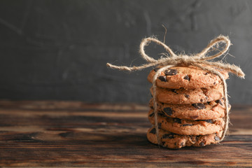 Stack of tasty chocolate chip cookies on wooden table. Space for text