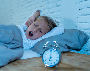 Cute girl feeling exhausted early in the morning having trouble getting up in Child insomnia concept
