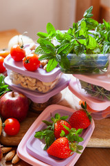 Filled plastic containers to save food, herbs and fruits fresh, concept of economy household