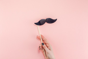 Woman hands with black paper moustaches