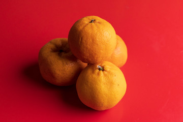 Orange fruits isolated on red background, Lunar Chinese New Year theme concept.