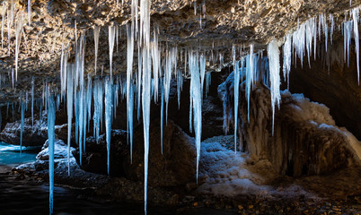 Many icicles hanging from the ceiling of the cave.