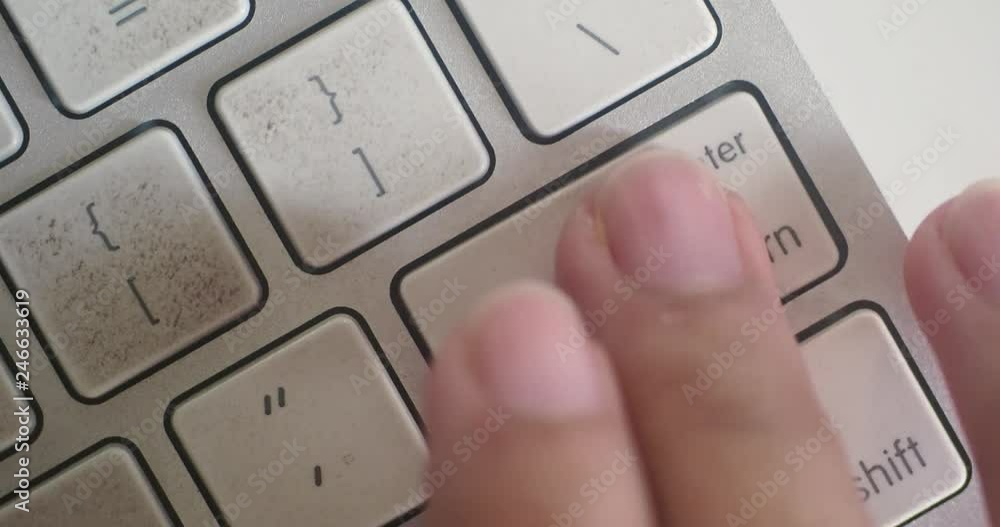 Poster close-up 4k shot of someone hitting the return/enter key on a mac keyboard.