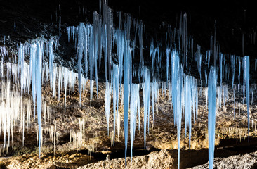 Many icicles hanging from the ceiling of the cave.