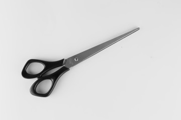 Closed scissors with black rings on a gray background