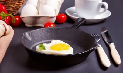 Heart shape scrambled eggs on iron dark pan