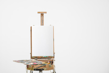 Artist easel with blank canvas on a white background.