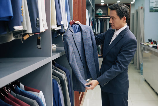 Businessman choosing casual everyday suit in fashion boutique