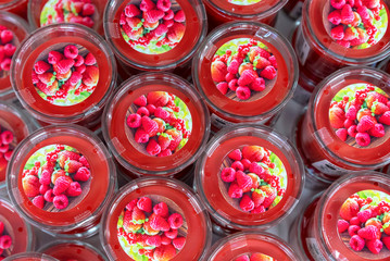 Red scented candles with raspberry flavor on the shop counter.