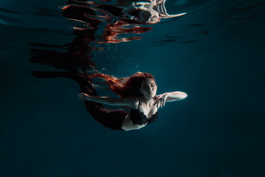 Underwater red haired mermaid freediver girl with tale