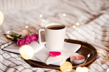 Cup of coffee with flowers on open book. Good  morning. Valentines Day.