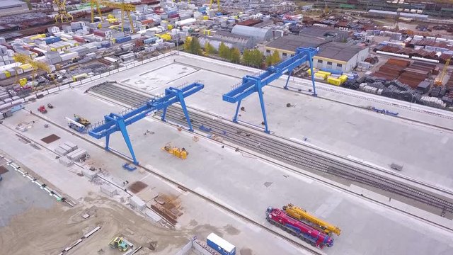 Top view of the gantry crane on the transport site. Clip. Various brands and colours of Shipping containers stacked by Transtainers Mobile gantry cranes off of service trucks