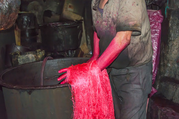 Tintorero, trabajador con las manos rojas teñidas por el tinte (pigmento) en Marrakech, Marruecos
